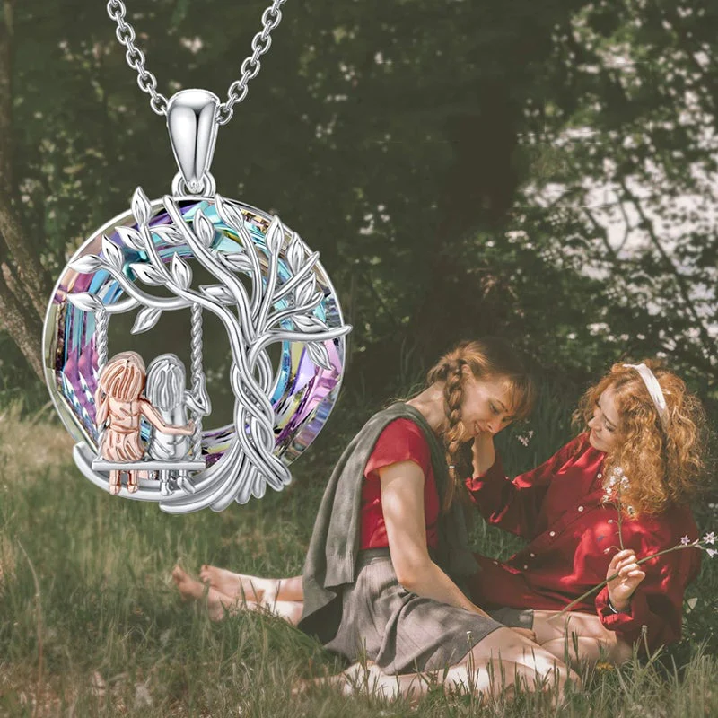 Detalle collar de dos hermanas en columpio bajo Árbol de la Vida